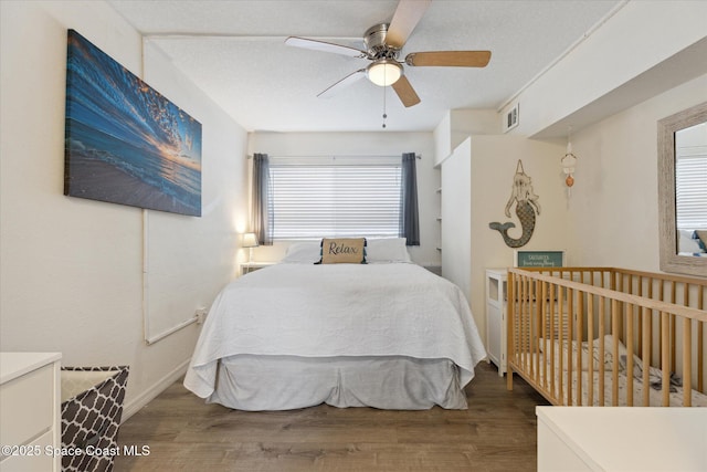 bedroom with visible vents, multiple windows, and wood finished floors