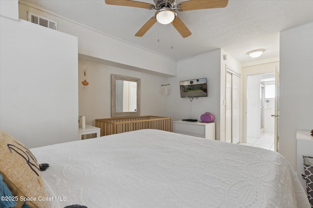 bedroom featuring a ceiling fan, visible vents, and a textured ceiling