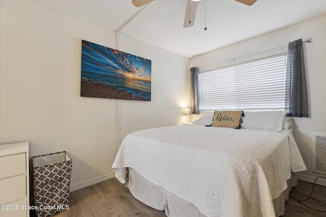 bedroom with a ceiling fan, baseboards, and wood finished floors