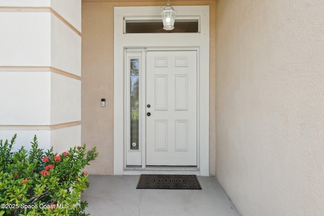 entrance to property featuring stucco siding