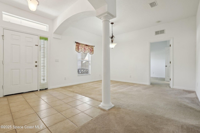 entryway featuring decorative columns, light colored carpet, visible vents, and light tile patterned flooring