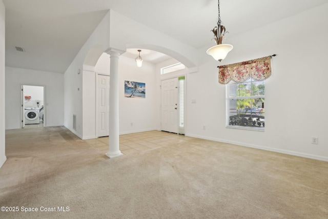 entrance foyer featuring visible vents, decorative columns, carpet floors, washer / dryer, and arched walkways