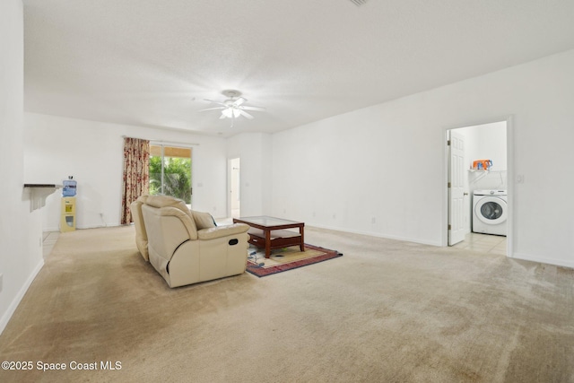 living room featuring baseboards, light colored carpet, washer / clothes dryer, and a ceiling fan