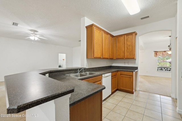 kitchen featuring a sink, visible vents, dark countertops, and dishwasher