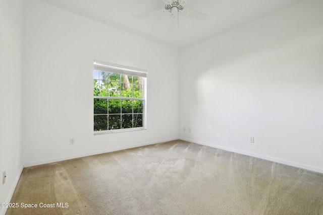 carpeted spare room with baseboards and ceiling fan