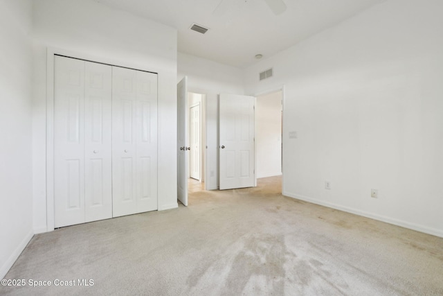 unfurnished bedroom featuring a closet, visible vents, baseboards, and carpet