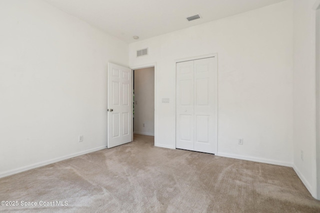 unfurnished bedroom featuring a closet, visible vents, baseboards, and carpet floors