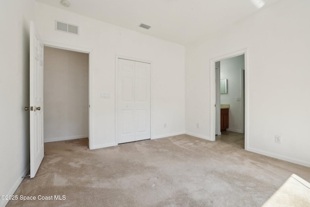 unfurnished bedroom featuring a closet, visible vents, and carpet floors