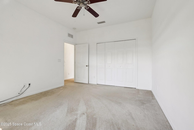 unfurnished bedroom with a closet, visible vents, carpet flooring, and a ceiling fan