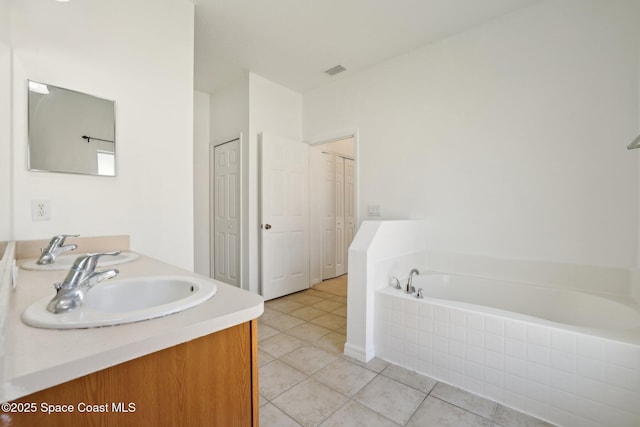 full bathroom featuring visible vents, double vanity, a sink, tile patterned floors, and a bath