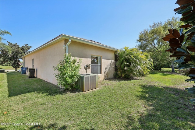 view of property exterior with cooling unit, a yard, and stucco siding