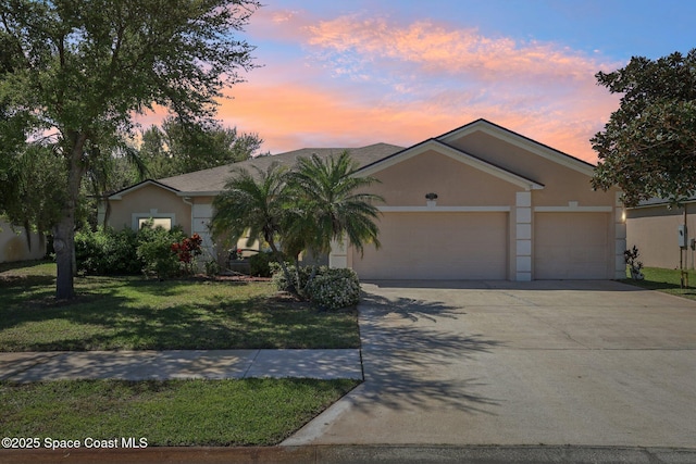 single story home with a yard, stucco siding, driveway, and a garage