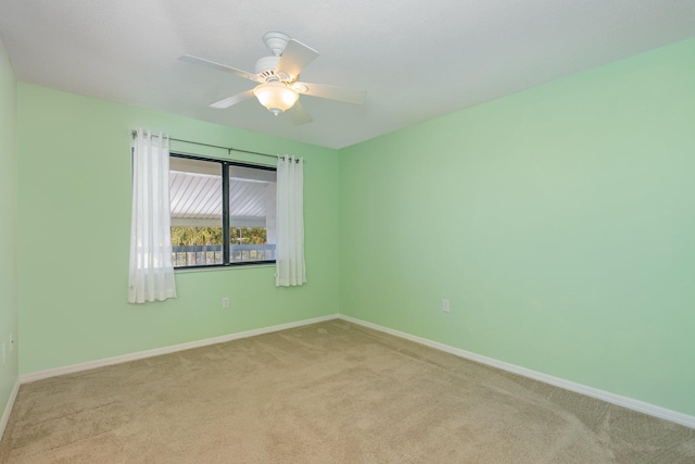 unfurnished room with light carpet, baseboards, and a ceiling fan