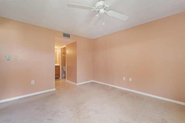 empty room with light colored carpet, visible vents, ceiling fan, and baseboards