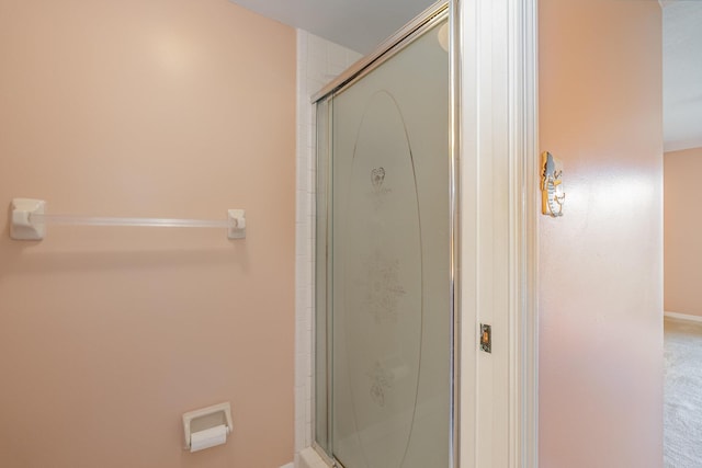 bathroom with a stall shower and baseboards