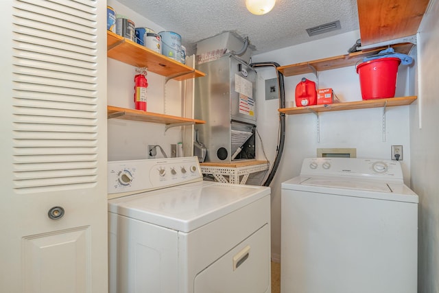 washroom featuring laundry area, visible vents, independent washer and dryer, and a textured ceiling