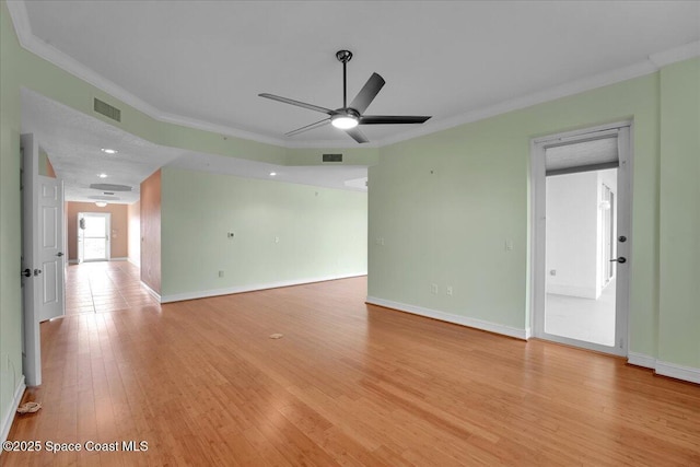 unfurnished room featuring baseboards, ornamental molding, visible vents, and light wood-style floors
