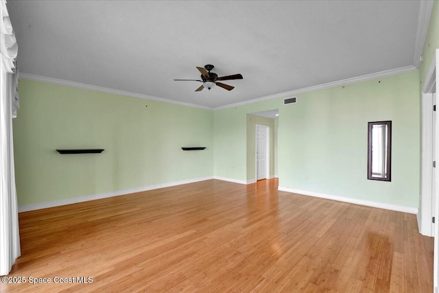 spare room featuring light wood finished floors, visible vents, ornamental molding, ceiling fan, and baseboards