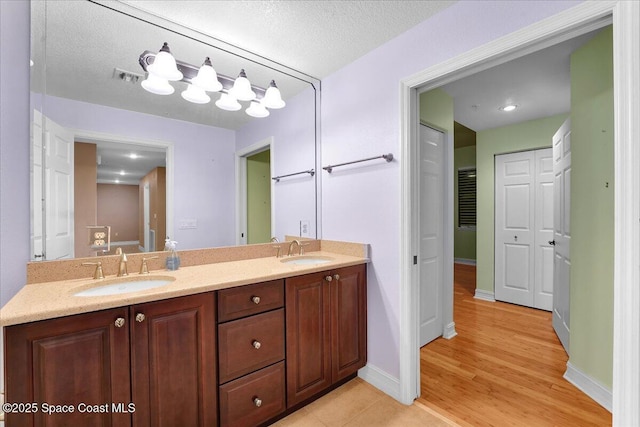 full bathroom featuring a closet, visible vents, a sink, and double vanity