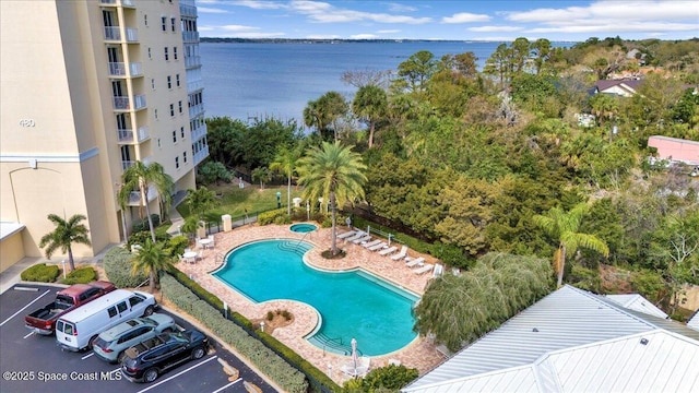 pool featuring a water view and a patio