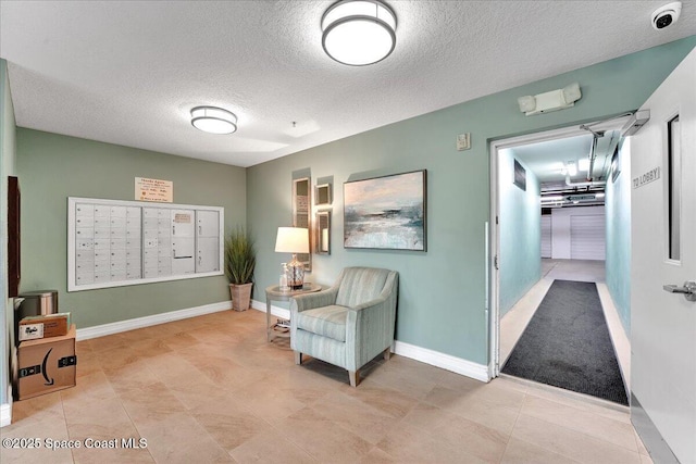 interior space featuring mail area, baseboards, and a textured ceiling