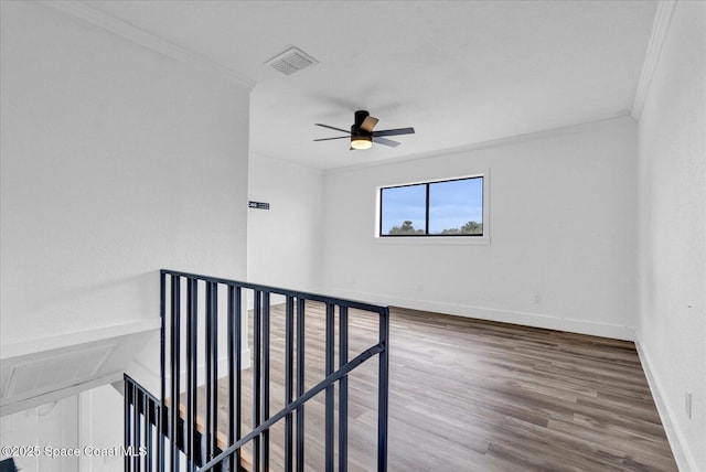 unfurnished room with visible vents, baseboards, a ceiling fan, ornamental molding, and wood finished floors