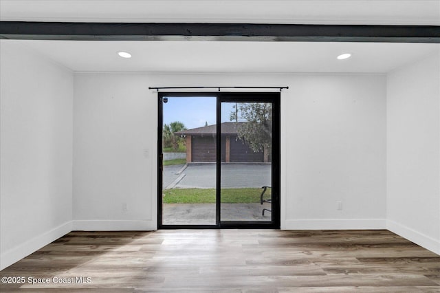 spare room featuring recessed lighting, wood finished floors, and baseboards