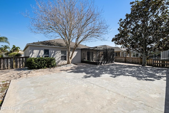 rear view of house with fence and stucco siding