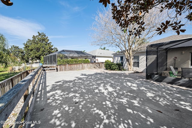 exterior space with a lanai, a patio area, a fenced backyard, and a residential view