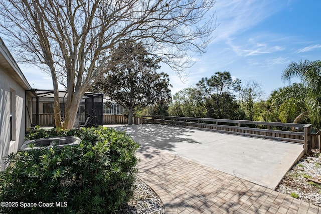 view of patio / terrace with a lanai and fence