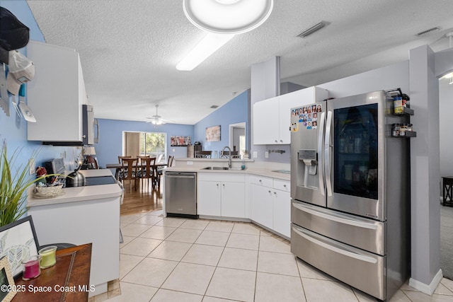 kitchen featuring stainless steel appliances, white cabinets, light countertops, and a sink