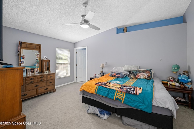 bedroom featuring ceiling fan, vaulted ceiling, a textured ceiling, and light colored carpet