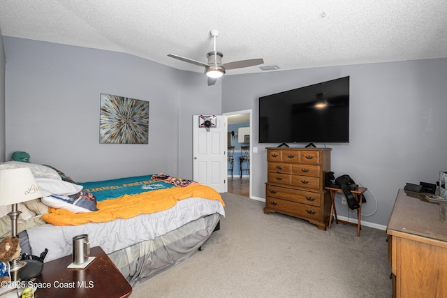 bedroom featuring visible vents, a ceiling fan, light colored carpet, vaulted ceiling, and a textured ceiling