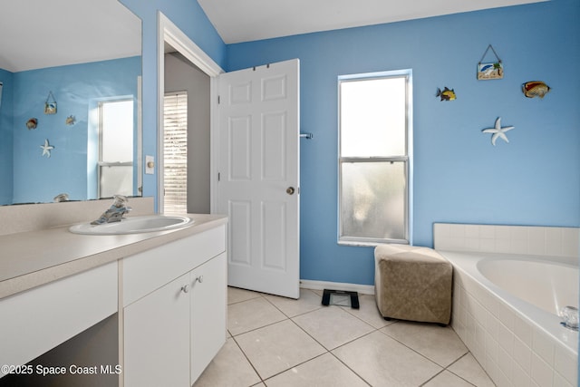 bathroom with vanity, tiled tub, tile patterned flooring, and a wealth of natural light