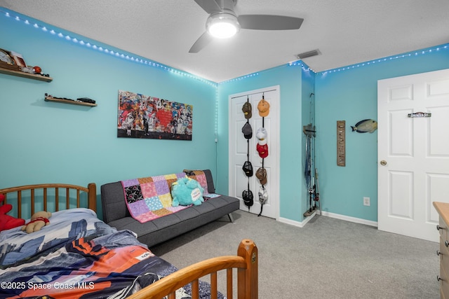 carpeted bedroom featuring ceiling fan, a textured ceiling, visible vents, and baseboards