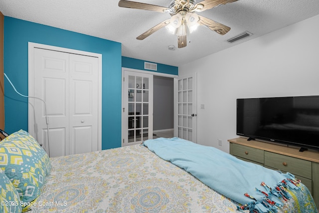 bedroom featuring a textured ceiling, french doors, a closet, and visible vents