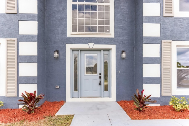 view of exterior entry featuring stucco siding