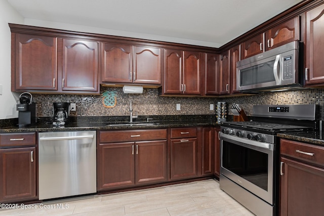 241 S Brevard Ave, Cocoa Beach, FL 32931 - kitchen with dark stone counters, a sink, stainless steel appliances, and tasteful backsplash