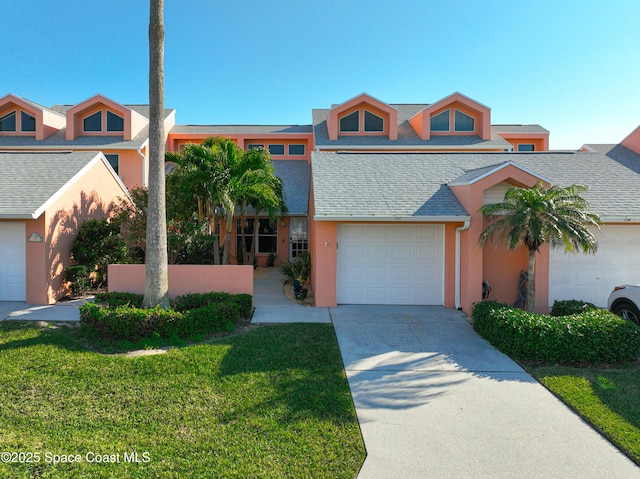 view of front of property featuring a garage, concrete driveway, roof with shingles, stucco siding, and a front yard