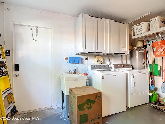 laundry area with a sink, washing machine and clothes dryer, and cabinet space