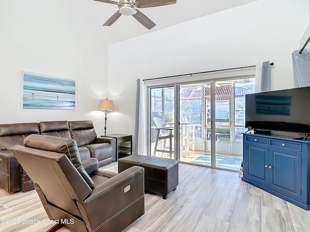 living area with light wood finished floors, ceiling fan, and high vaulted ceiling