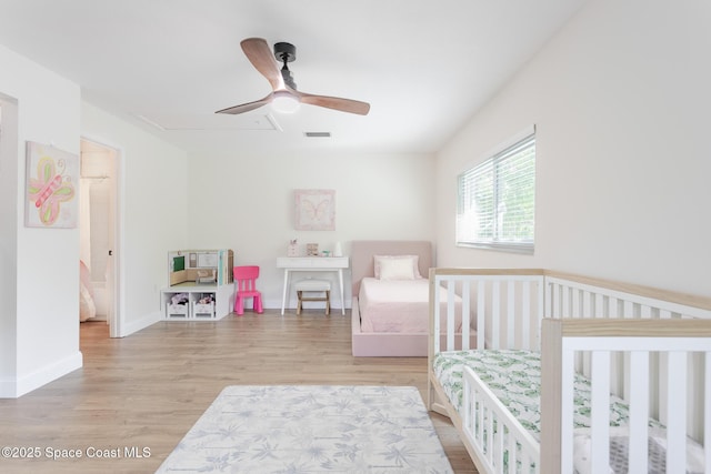 bedroom with ceiling fan, light wood finished floors, visible vents, and baseboards