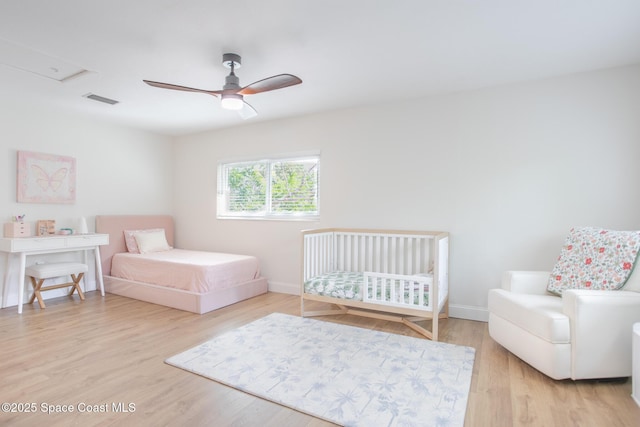 bedroom featuring a ceiling fan, baseboards, visible vents, and wood finished floors