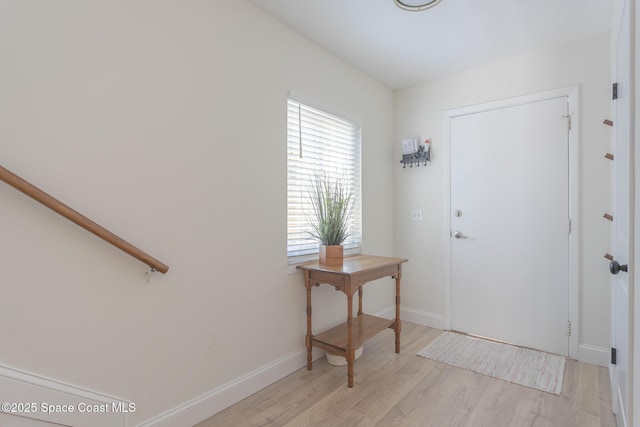 foyer entrance featuring light wood-style flooring and baseboards