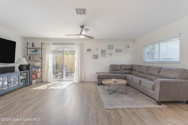 living room with a ceiling fan, light wood-type flooring, a healthy amount of sunlight, and visible vents