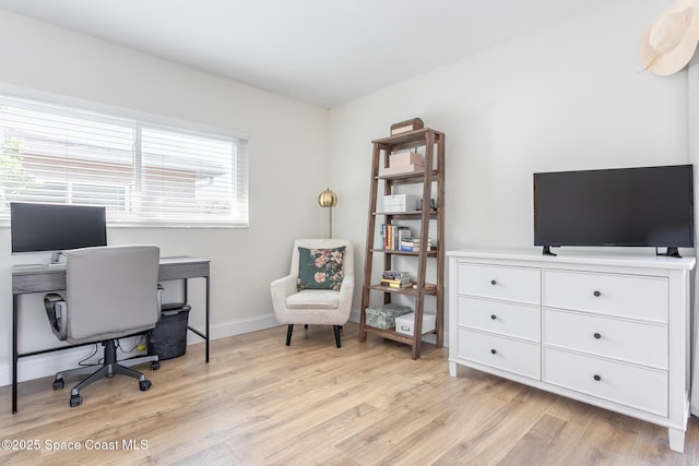 office space with baseboards and light wood finished floors