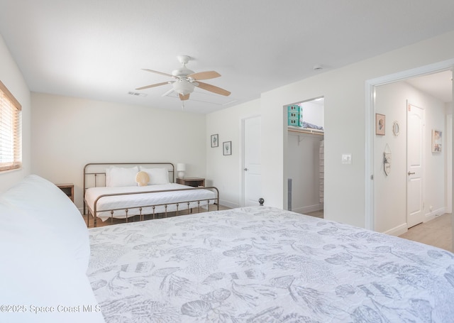 bedroom with a ceiling fan, visible vents, a spacious closet, and baseboards