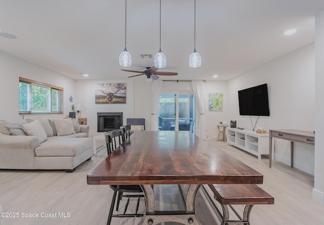 living room with light wood-style floors, recessed lighting, visible vents, and a fireplace