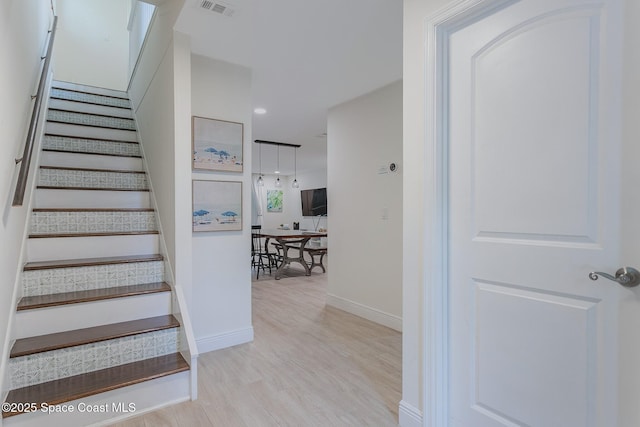 staircase with recessed lighting, wood finished floors, visible vents, and baseboards