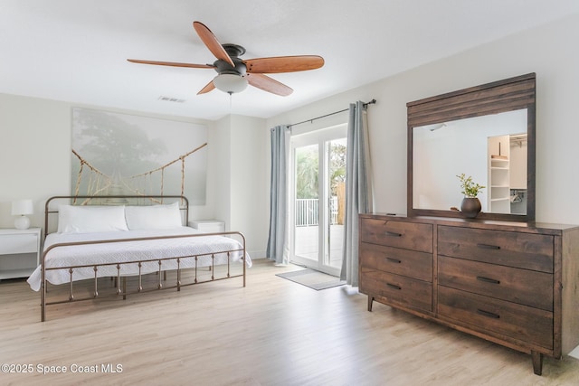 bedroom with access to exterior, visible vents, light wood-style flooring, and a ceiling fan